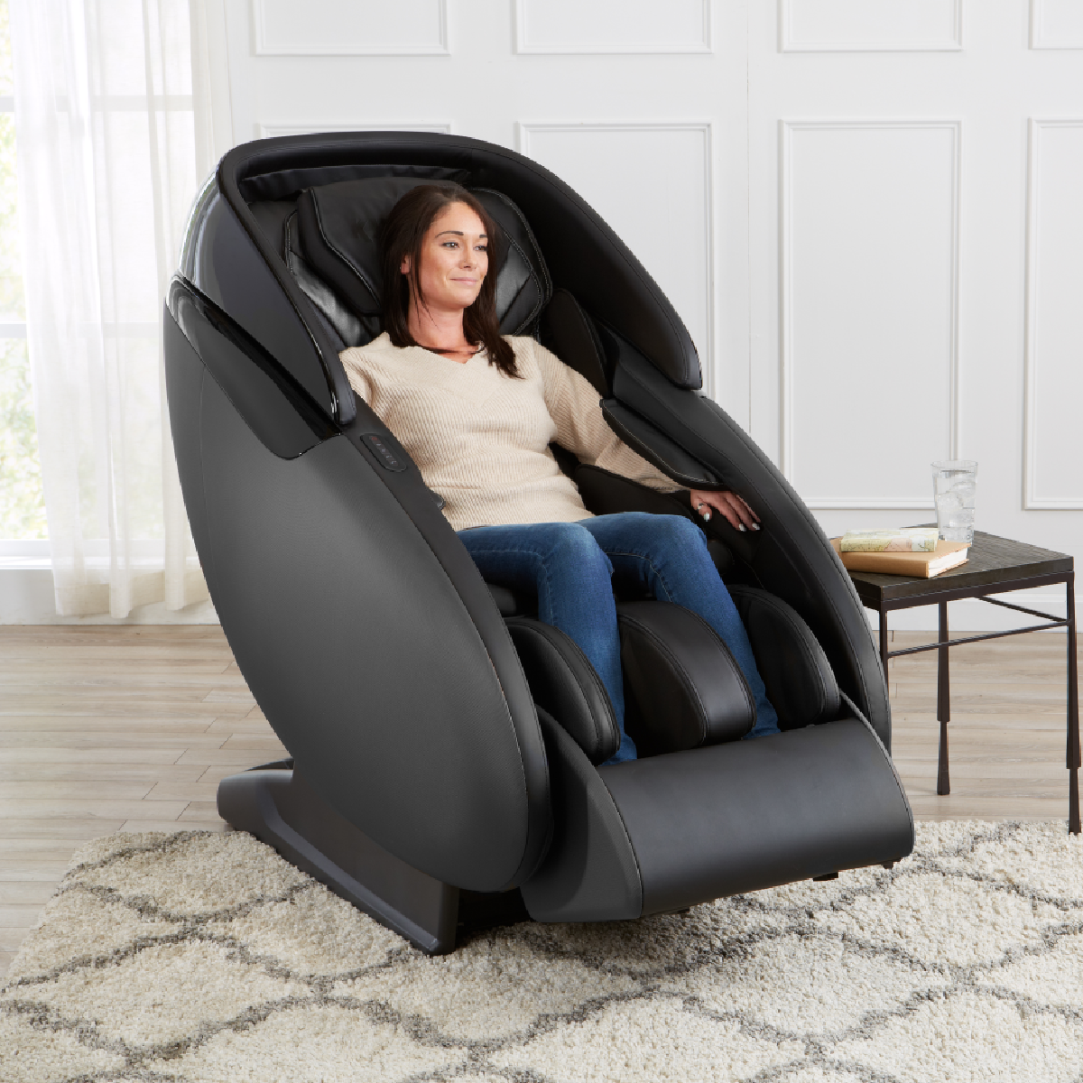 Kyota Kaizen Massage Chair M680 in Black in interior with a woman inside - Home Bars USA