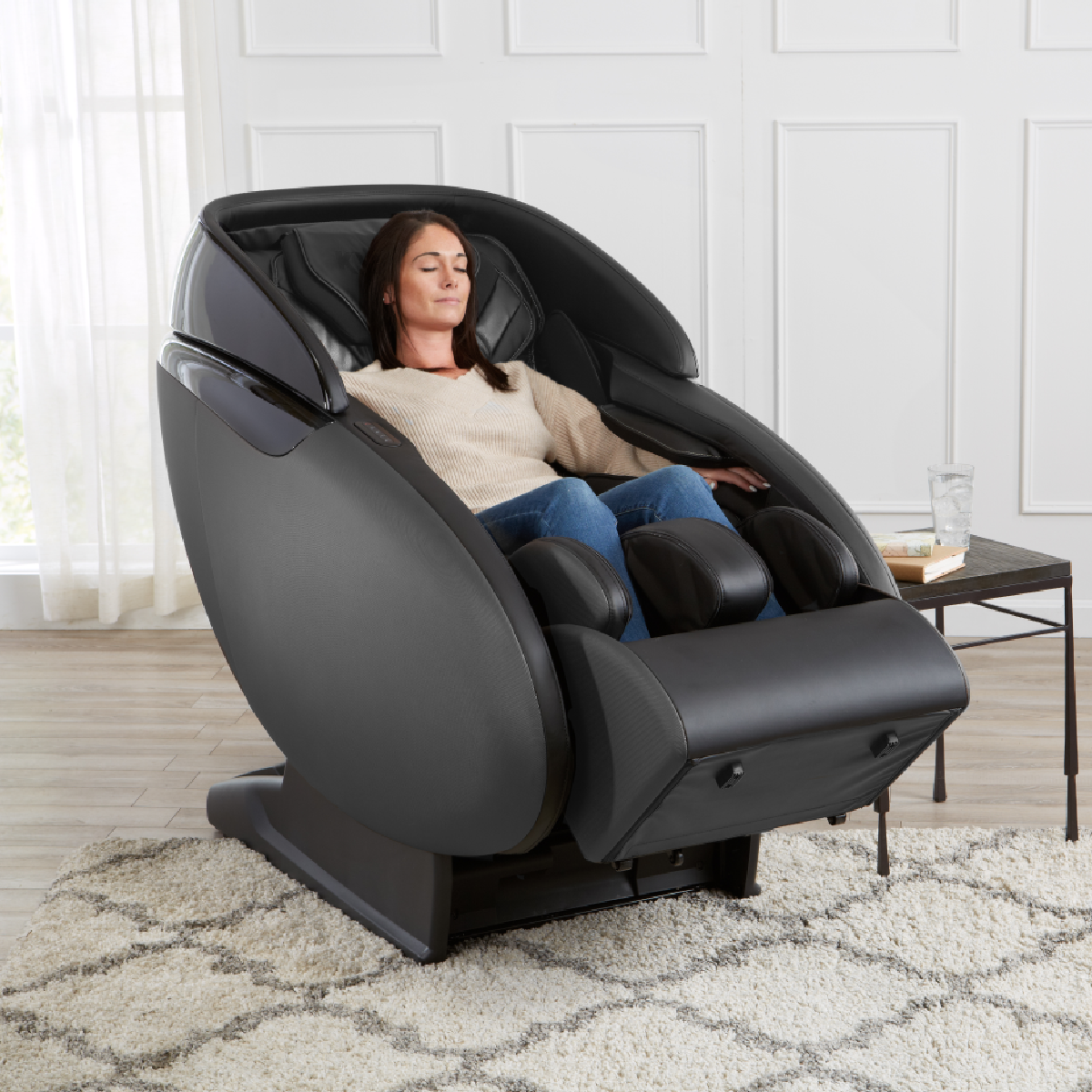 Kyota Kaizen Massage Chair M680 in Black in interior reclined with a woman inside - Home Bars USA